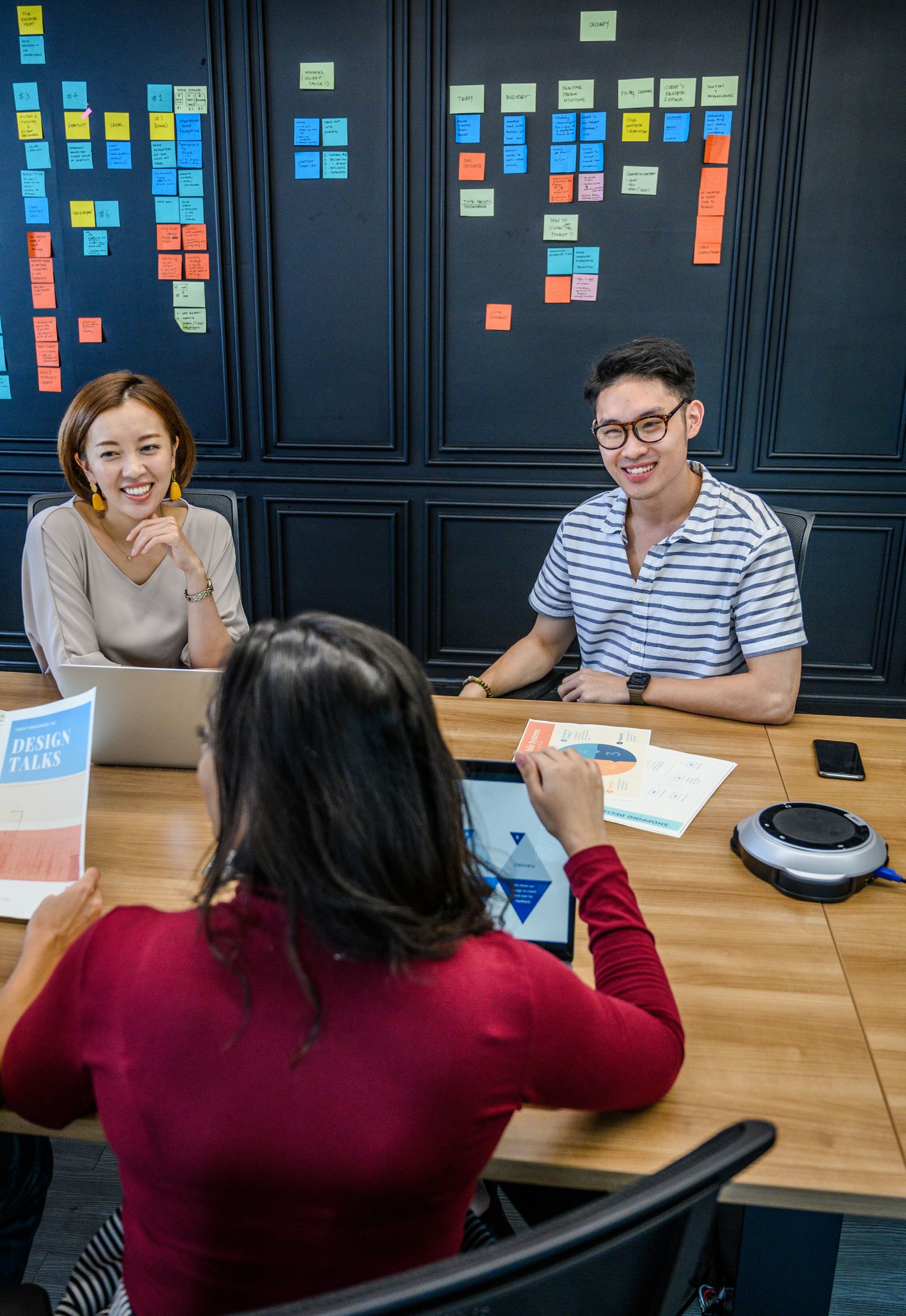 Team discussing a workflow in front of a wall of process notes