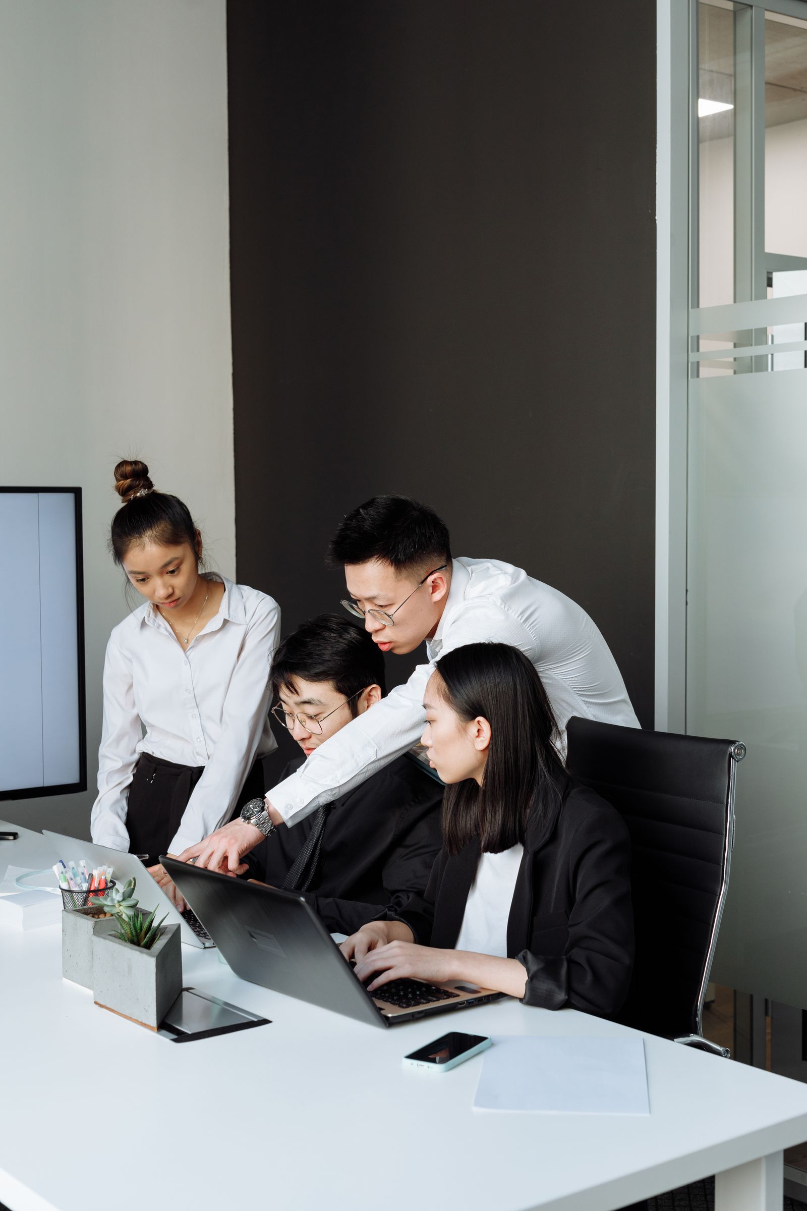 Operations team reviewing a shared system around two laptops